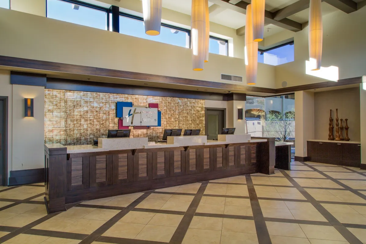 A professional and inviting reception area with a sleek desk, modern lighting fixtures, and artful decor. The environment feels welcoming, emphasizing attentive service and first impressions.